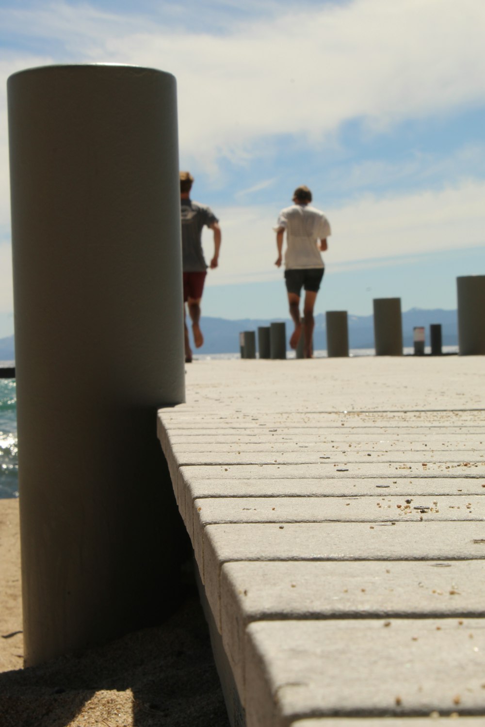 a couple of men walking on a boardwalk