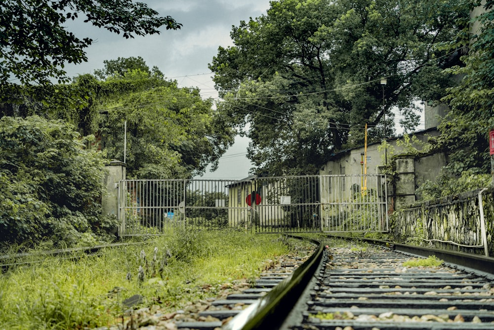 train tracks going through a fence