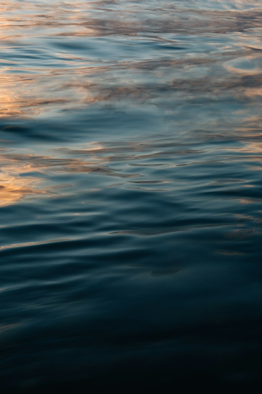 a body of water with clouds above it