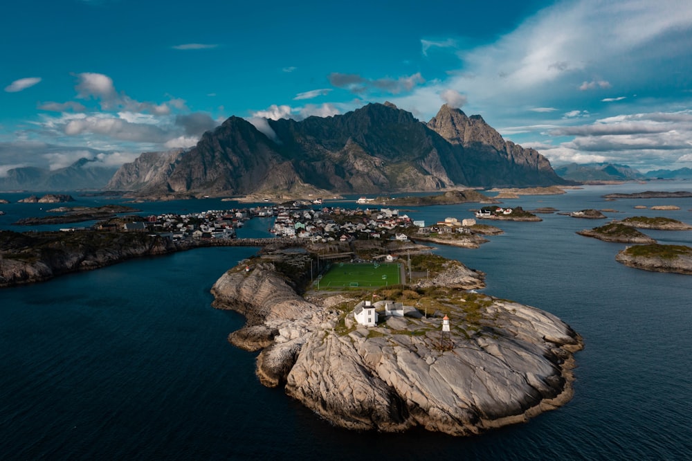 a small town on a rocky island with Lofoten in the background