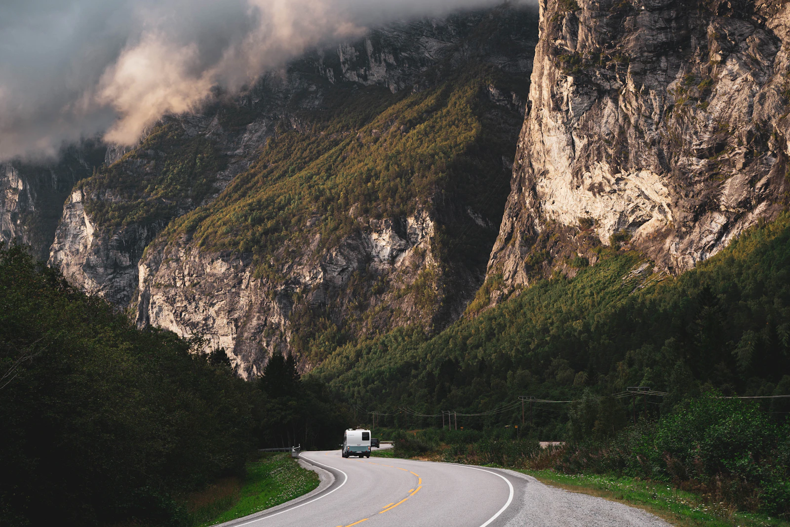 A narrow Norwegian road runs between mountains