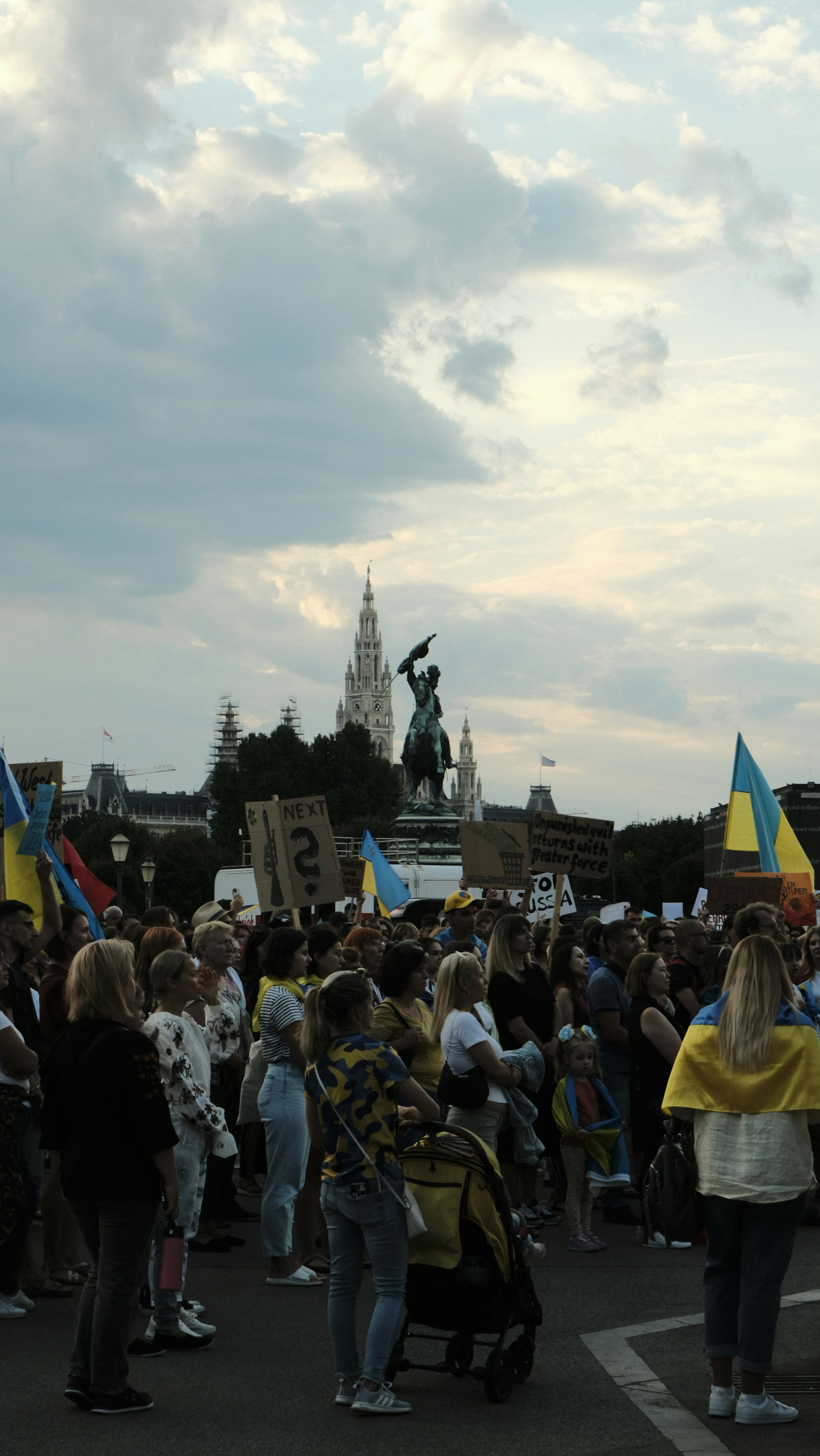 a crowd of people standing in front of a statue