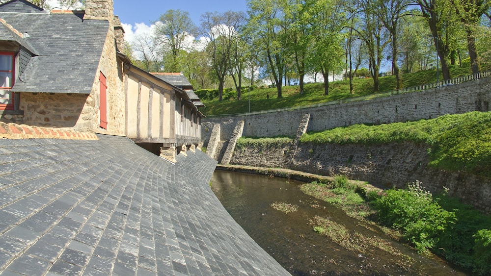 a stone walkway with a stone wall and a brick wall and trees