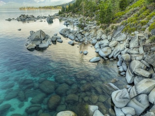 A tranquil nature scene with soft turquoise waters and smooth stones.