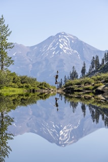 a lake with a mountain in the background and person feeling happy and calm