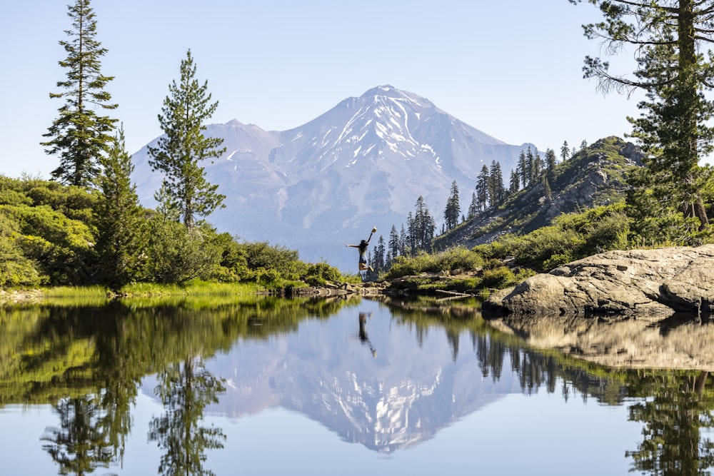 a lake with trees and mountains in the background