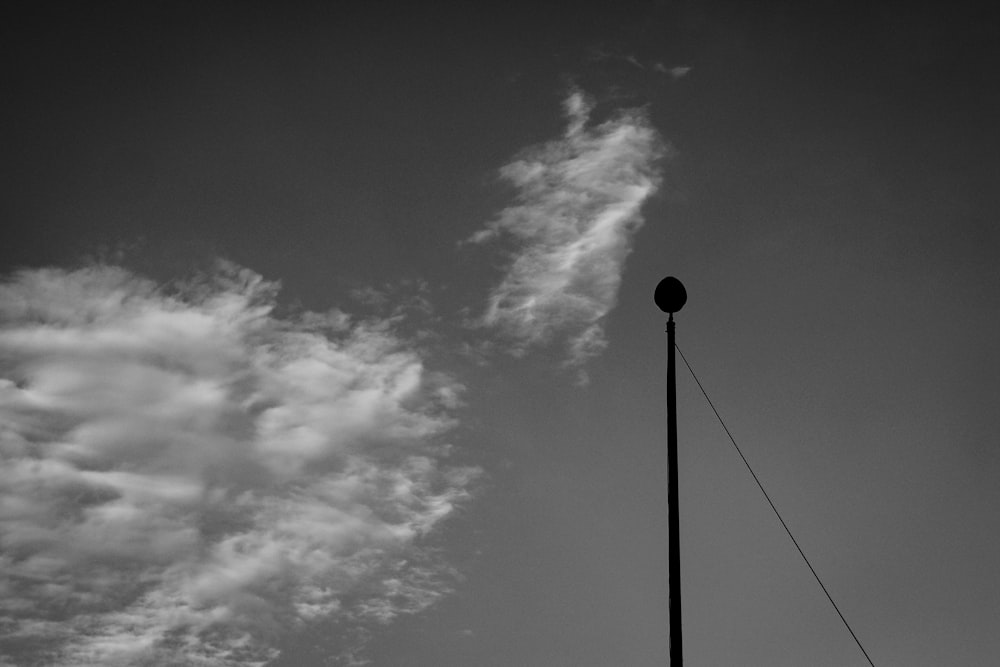 a light post with clouds in the background