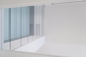 a white wall with a glass door