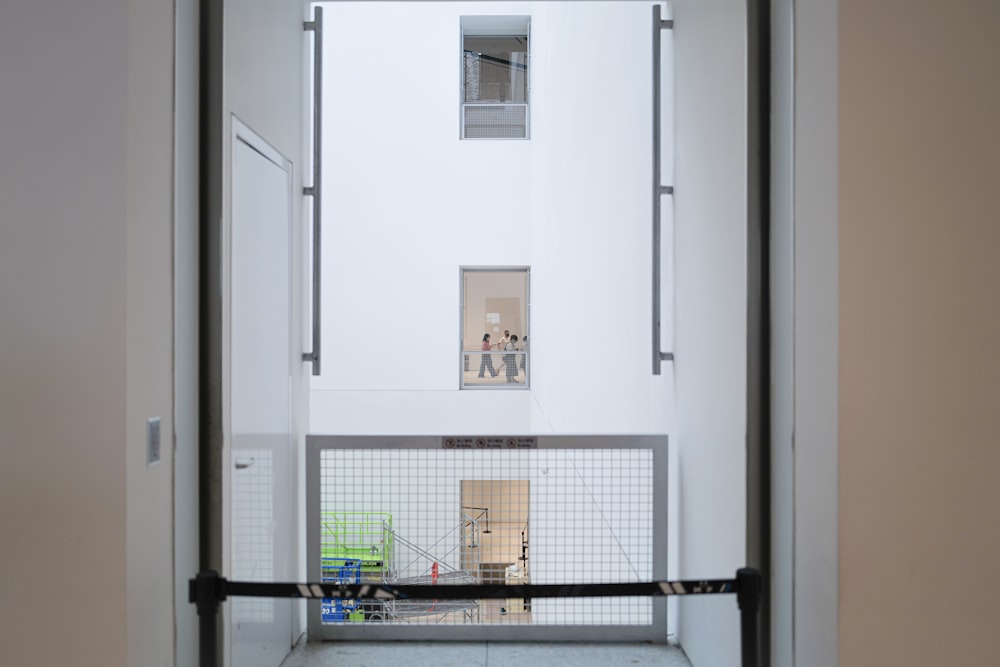 a room with a white door and a metal cage with a person in it