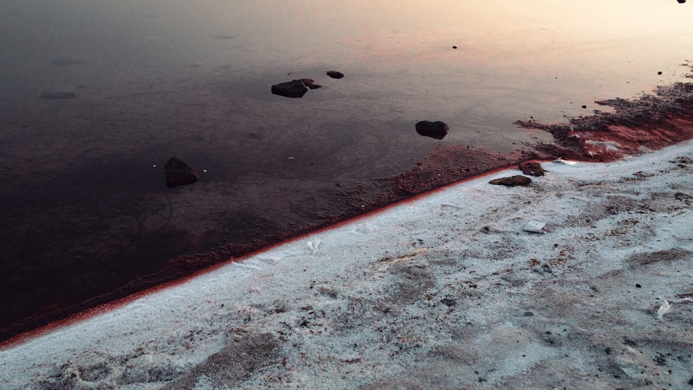 a sandy beach with rocks and water