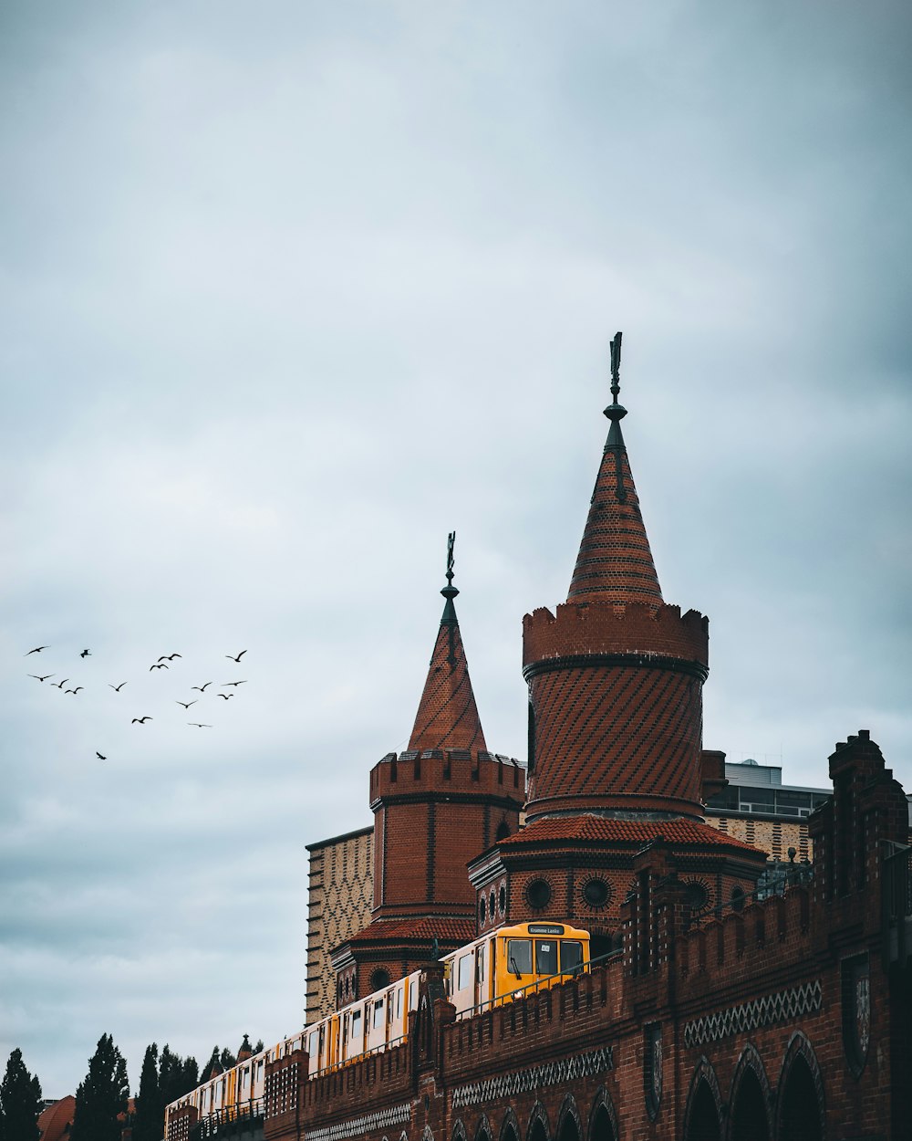 a building with towers and birds flying around