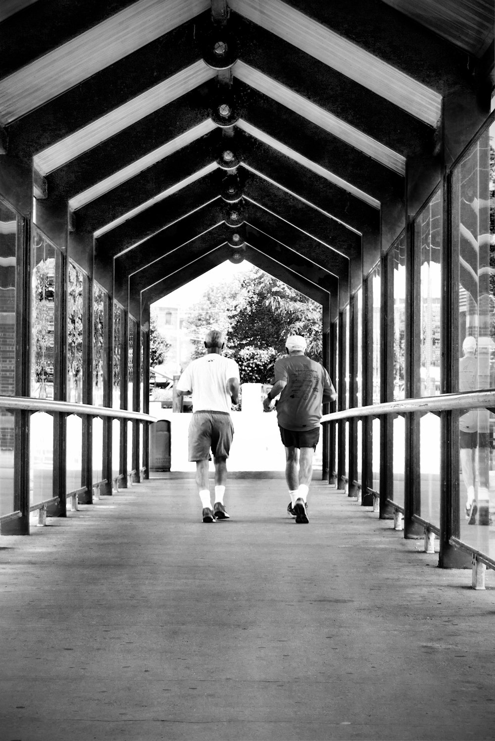 a couple of men walking on a bridge