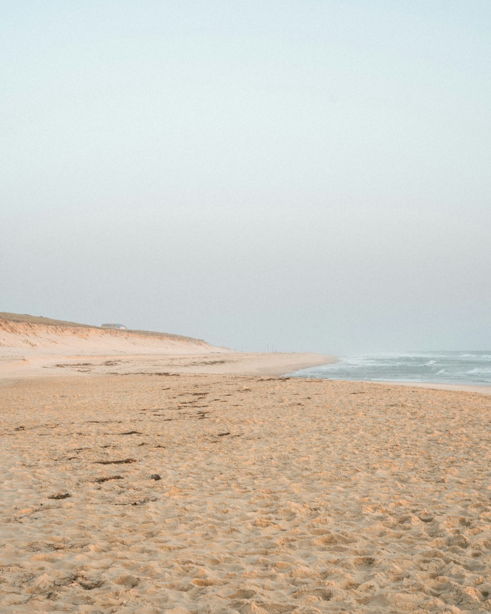 uma praia de areia com água e céu azul