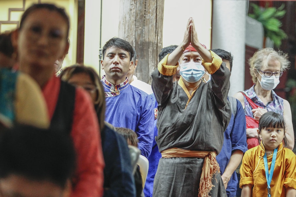 a group of people standing around a person in a garment