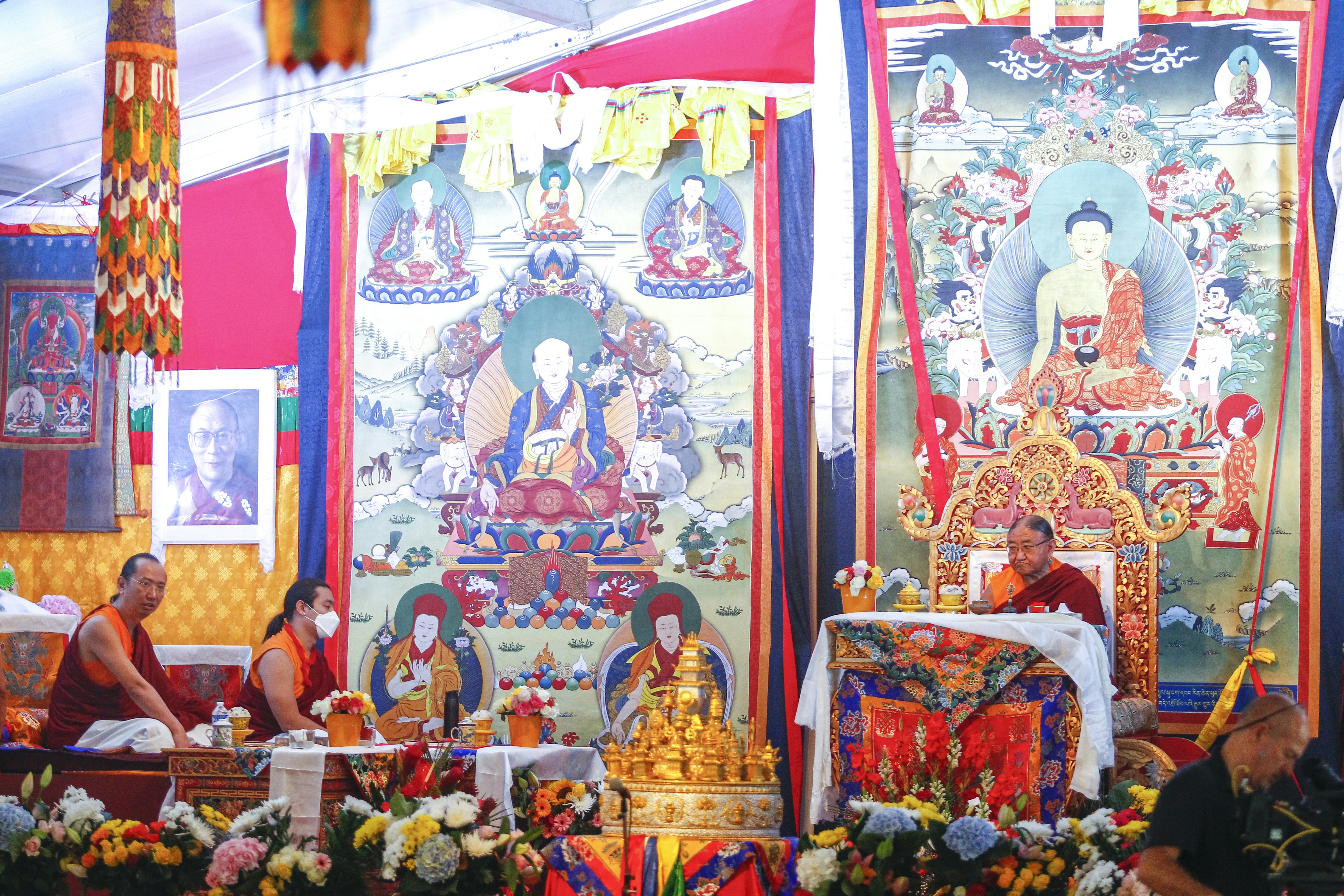 a group of people sitting in a room with a wall of religious art