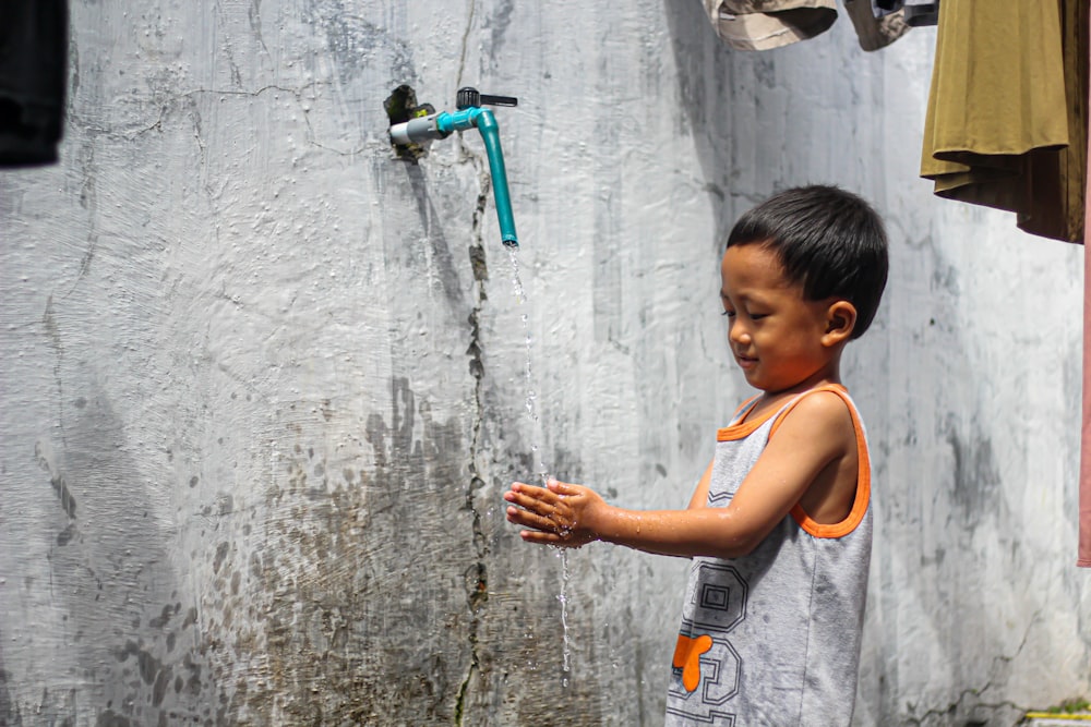 a young boy painting a wall