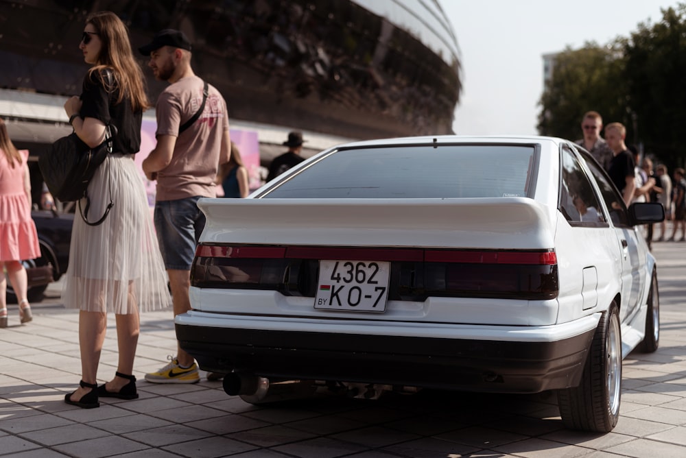 a car parked on a street with people around it