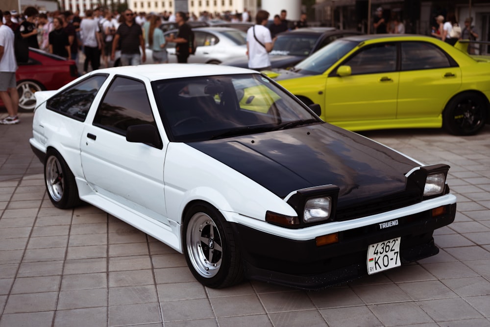 a white car parked in a showroom with other cars