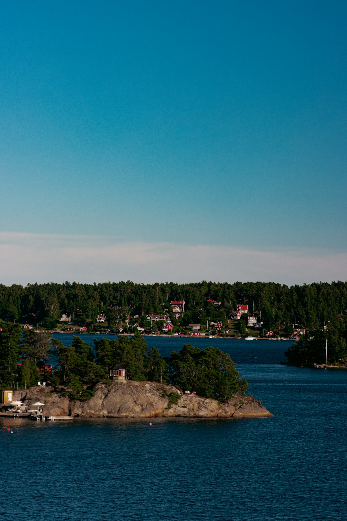Djurgården Stockholm — traditional red Swedish buildings by the water with autumn trees