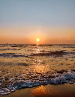 Sunset over a calm beach with tourists enjoying a guided kayak tour on crystal clear waters