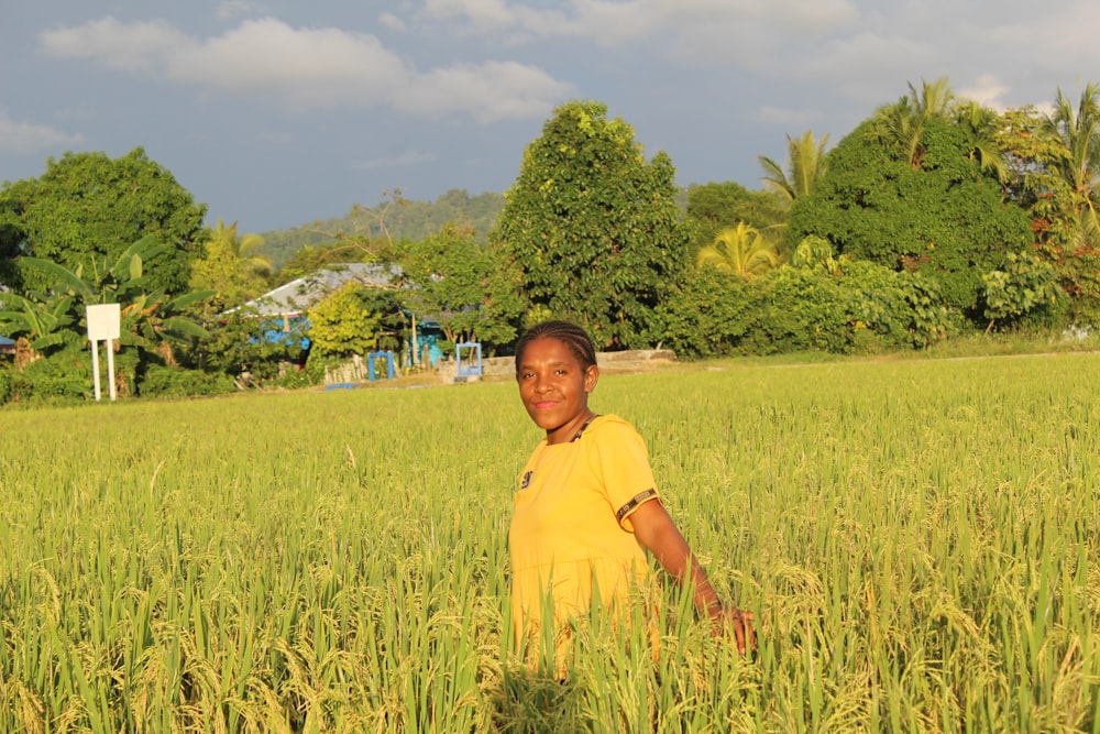 a boy standing in a field of tall grass