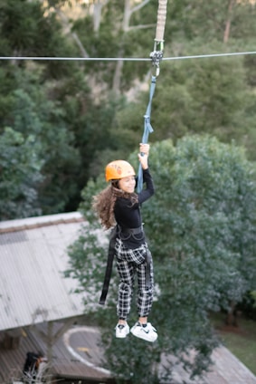 Adventure park zipline setup with safety harnesses and lush forest background.