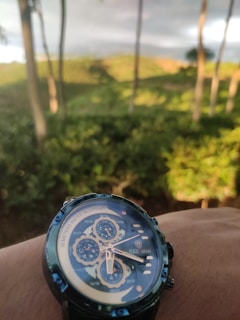 A Timelens watch worn on a wrist outdoors, with a blurred cityscape in the background