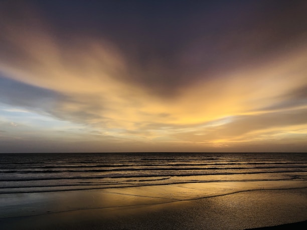 A tranquil beach scene with gentle waves and warm golden hues, inviting a sense of peace and connection.