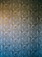 A sleek geometric art deco pattern with gold sunburst accents on deep navy background.