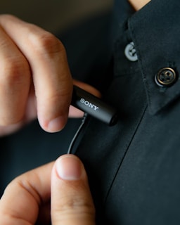 Close-up of a sleek lapel microphone clipped onto a musician's shirt during a live performance