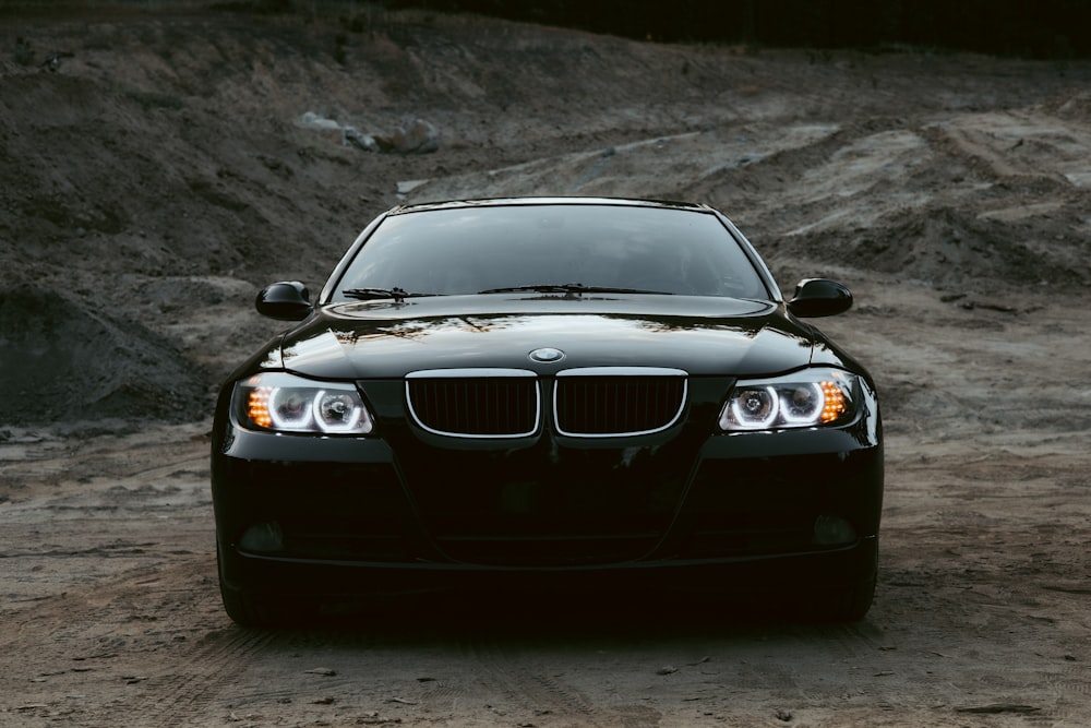 a black car driving on a dirt road