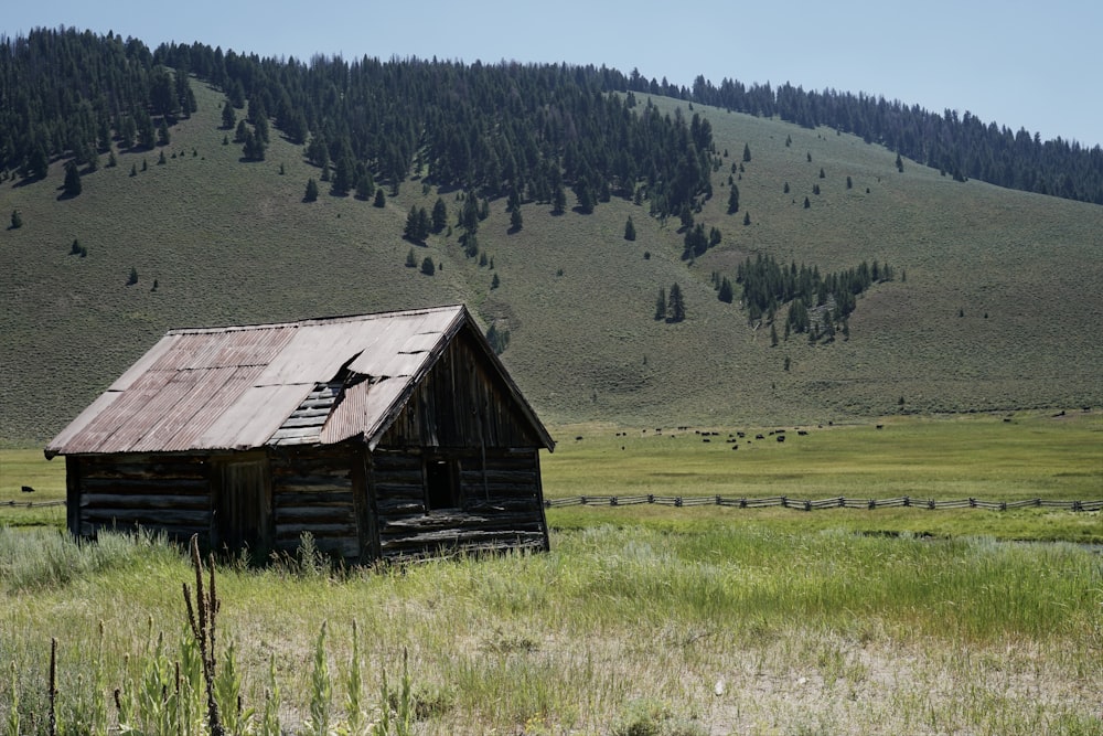 a wooden building in a field