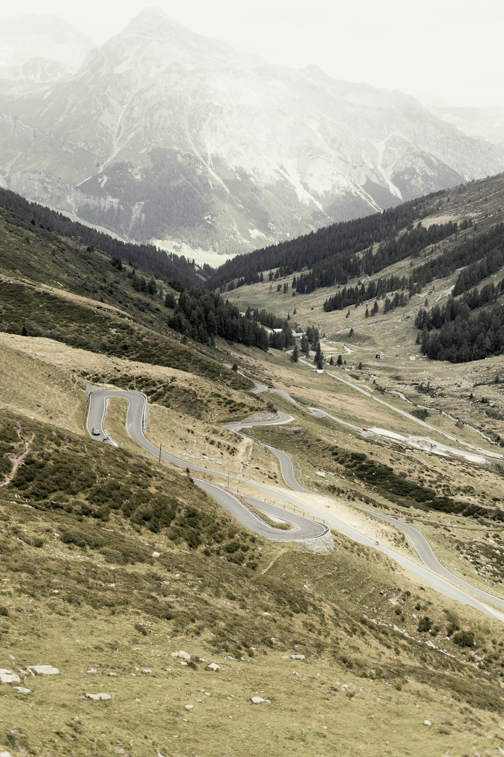 a road in a valley with mountains in the background