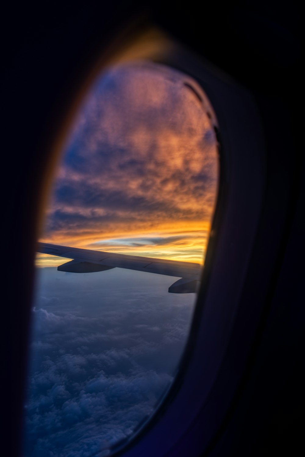 an airplane wing with the sun setting