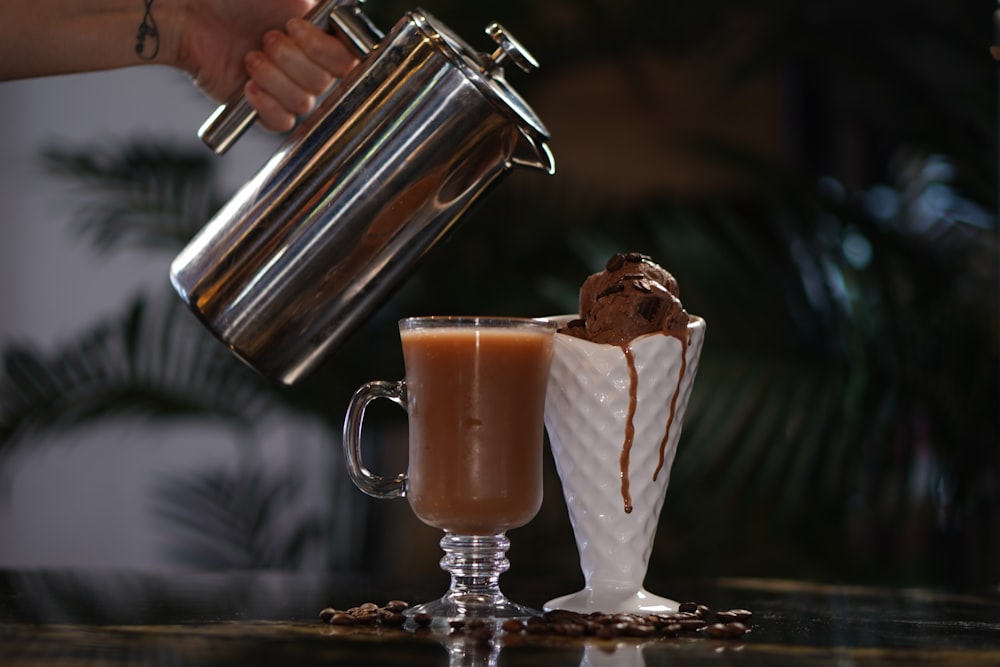 a person pouring a drink into a glass