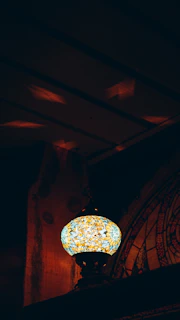 A glowing mosaic Turkish lamp casting colorful patterns on a warm beige background
