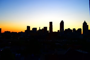 A vibrant aerial shot of a city skyline at sunset, highlighting sharp contrasts and bold colors.