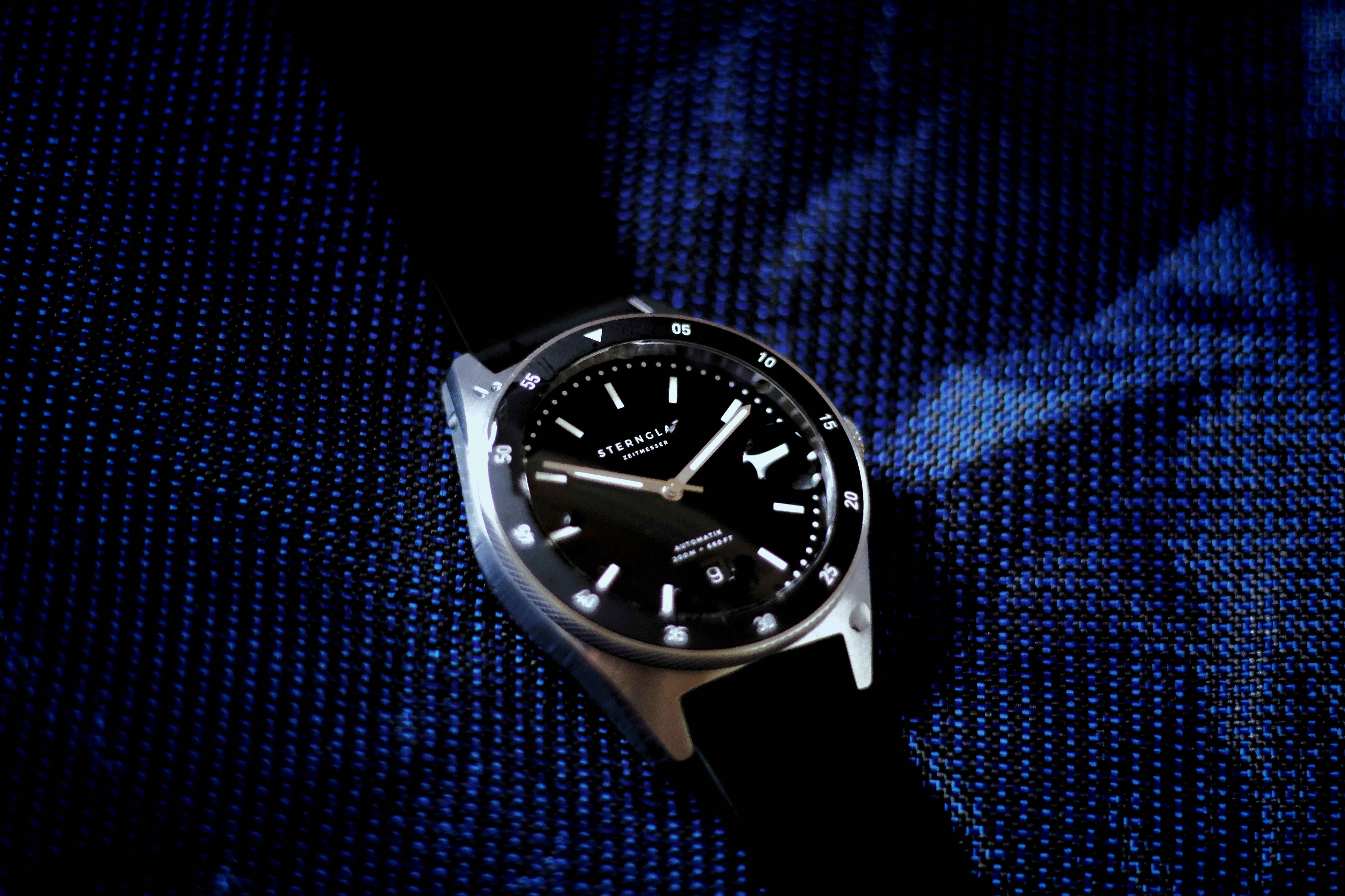 a black watch on a blue surface