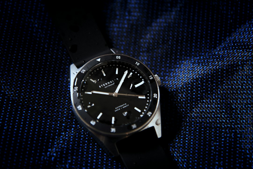 a black watch on a blue surface, The Sternglas Marus is a classic automatic diving watch with a rotating bezel and a wat