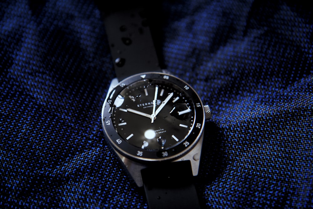 a black watch on a blue surface