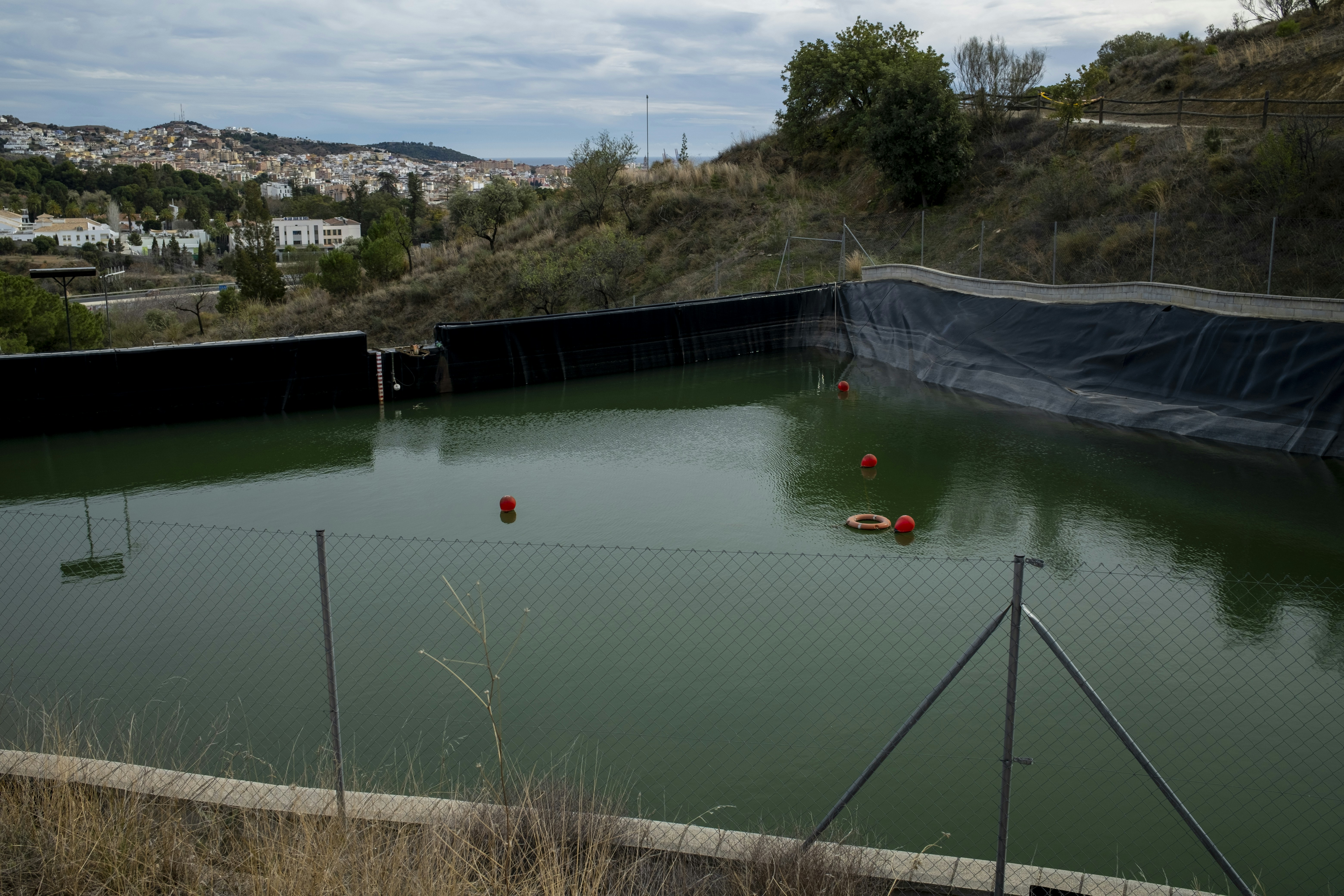 a body of water with a bridge and buildings in the background