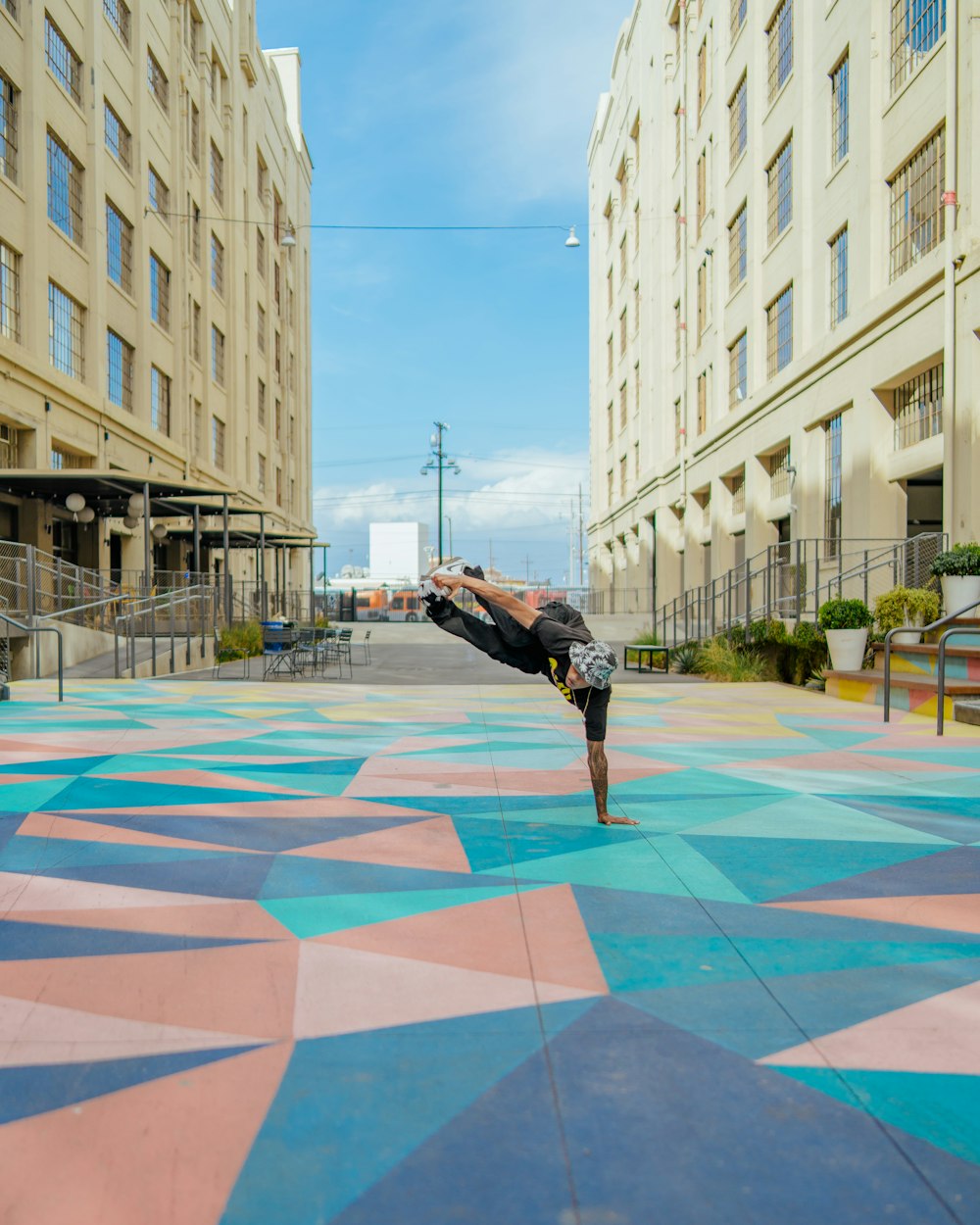 a person doing a handstand on a colorful mat in a city