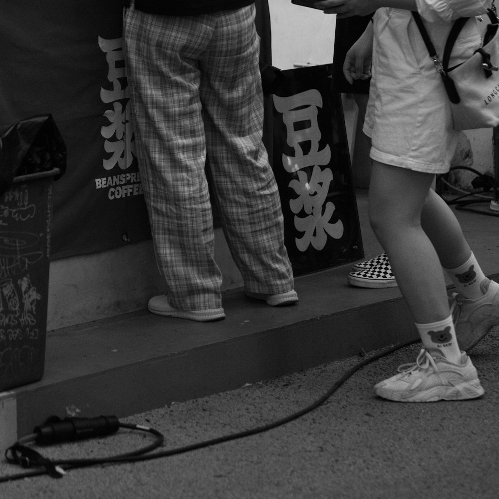 a couple of people standing next to a sign