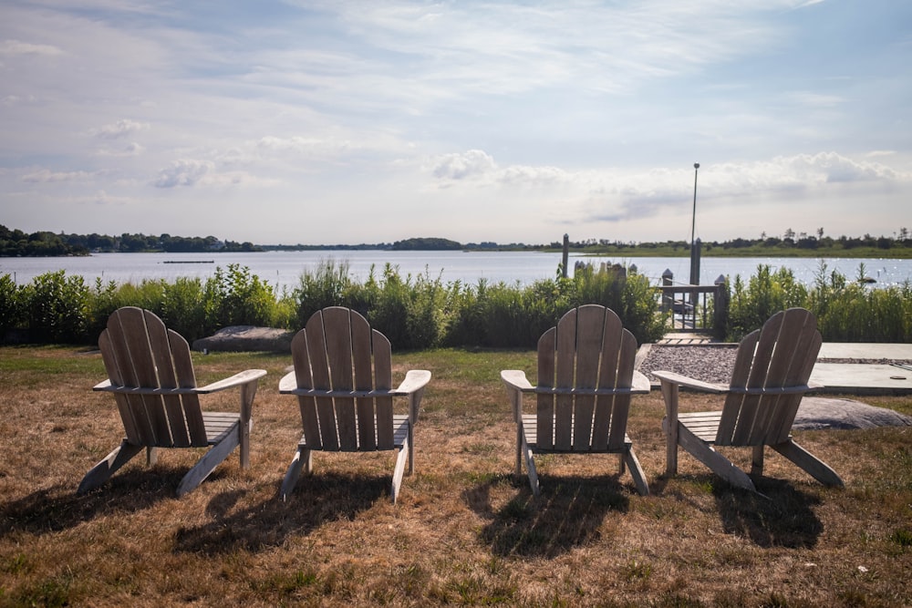 a table and chairs on a grassy area with a body of water in the background