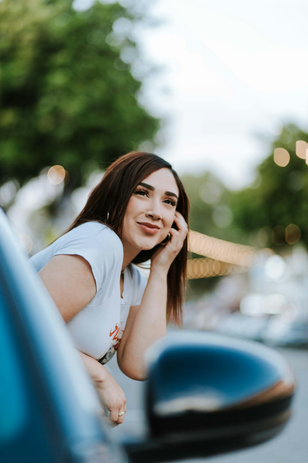 a woman leaning on a car