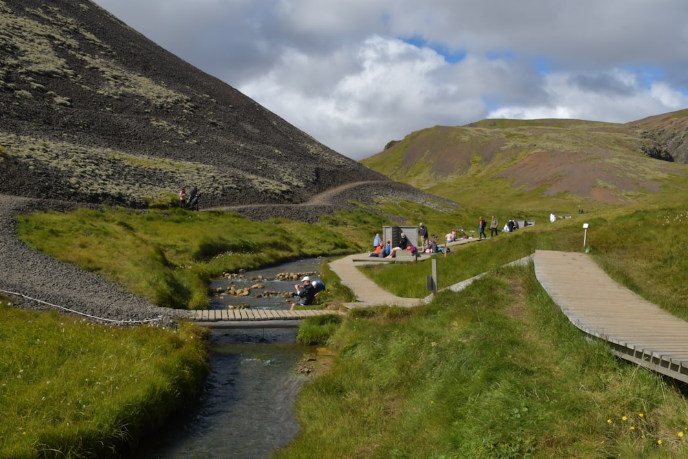 a group of people walking on a path in a valley between mountains