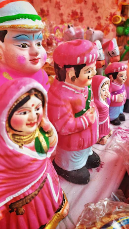 Close-up of colorful handmade clay figures arranged on a wooden table.