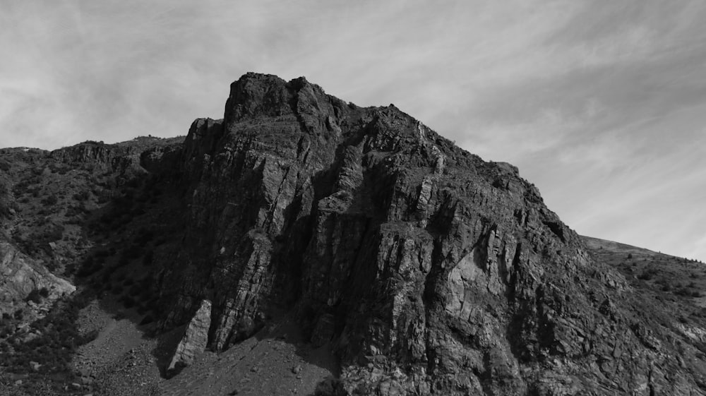 a rocky mountain with a cloudy sky