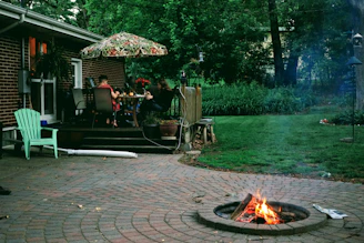 a fire pit with a couple people sitting at a table with a fire
