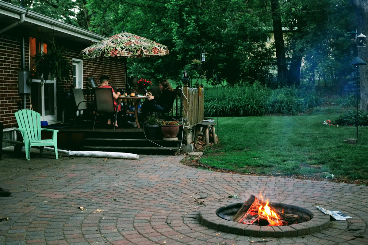 a fire pit with a couple people sitting at a table with a fire